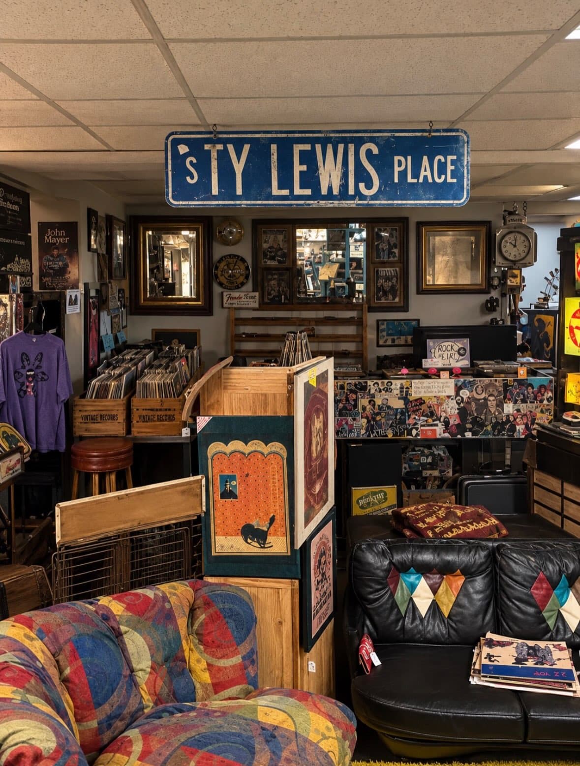 Corner of Vintage Finds Antiques with vinyl record crates, framed posters, mirrors and a colorful 1970s sofa